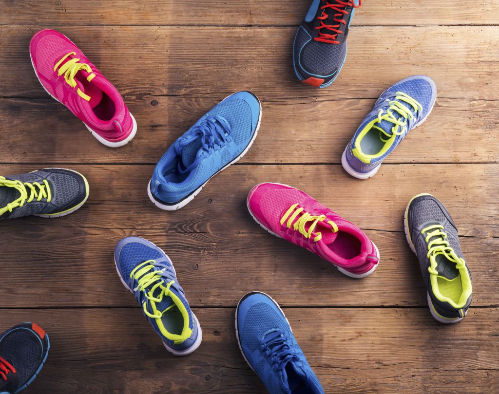 sepatu running oranye dengan desain sol yang terlihat jelas saat digunakan untuk berlari di luar ruangan, menunjukkan daya cengkeram yang kuat pada permukaan.
