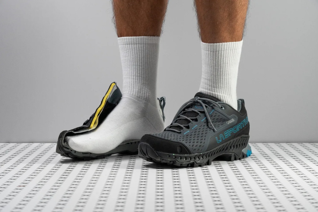 Sepatu hiking La Sportiva dengan satu sepatu dibelah untuk memperlihatkan struktur dalam, midsole, dan desain outsole.