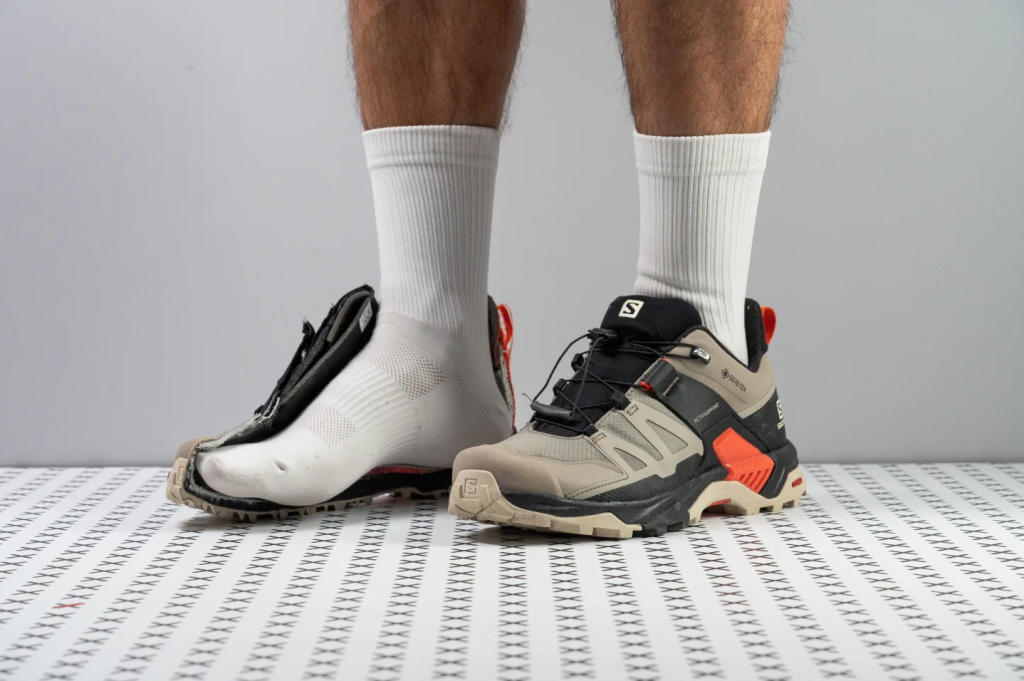 Sepatu hiking Salomon diperlihatkan dengan potongan setengah untuk menunjukkan struktur dalam dan konstruksi midsole.