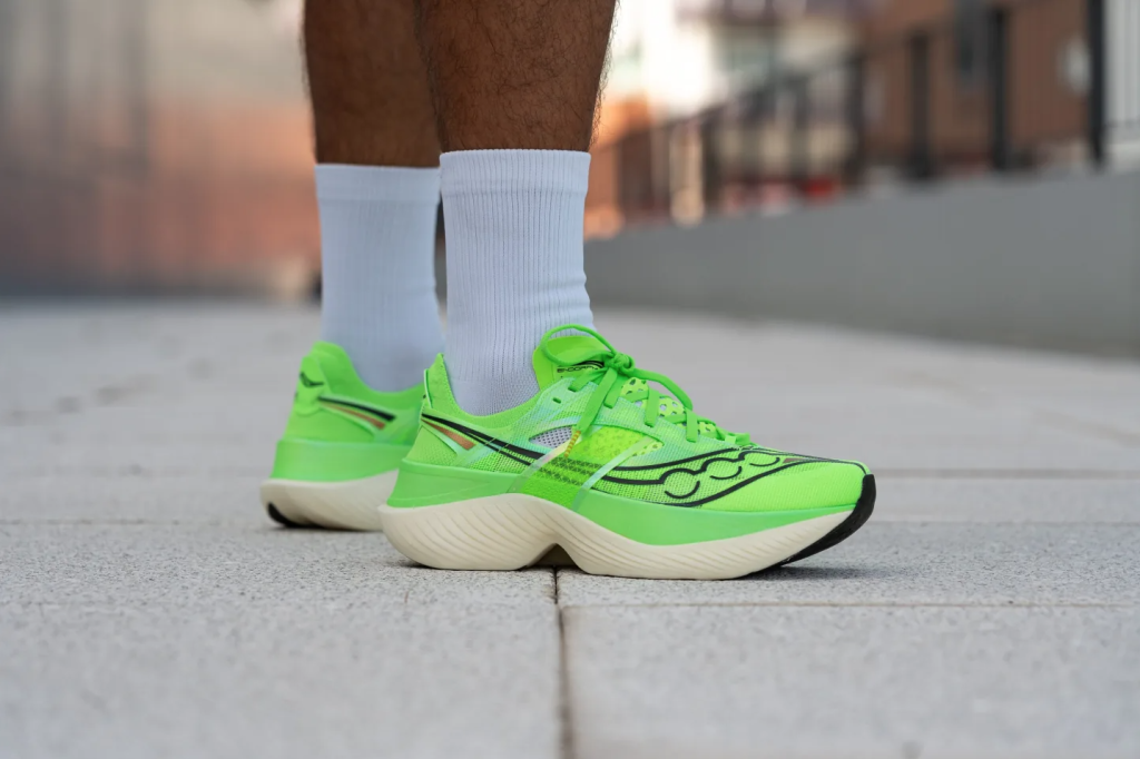 Sepatu lari Saucony Endorphin Elite berwarna hijau dengan midsole PWRRUN HG dan plate karbon.